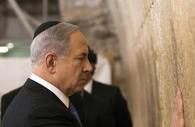 Prime Minister Benjamin Netanyahu touches the stones of the Western Wall (photo credit: REUTERS)