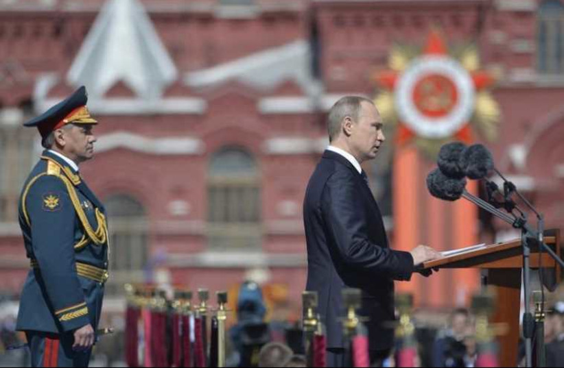 Russia's President Vladimir Putin (R) delivers a speech as Defense Minister Sergei Shoigu stands nearby during the Victory Day parade at Red Square in Moscow