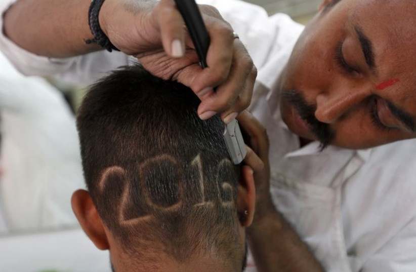 A man gets a haircut depicting 2016 at a barbershop in Ahmedabad, India