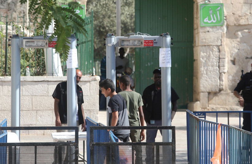 POLICE OFFICERS man a metal detector placed this week at an entrance to the Temple Mount (photo credit: MARC ISRAEL SELLEM/THE JERUSALEM POST)