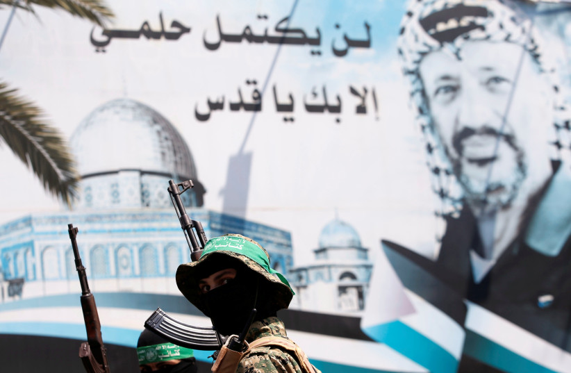 A poster depicting late Palestinian leader Yasser Arafat is seen as Hamas militants take part in a protest against Israel's new security measures at the entrance to the al-Aksa mosque (Temple Mount) compound, in Gaza City July 21, 2017.  (photo credit: REUTERS)