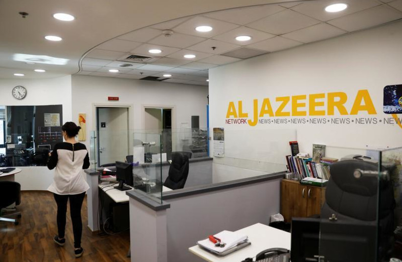 An employee walks inside an office of Qatar-based Al-Jazeera network in Jerusalem June 13, 2017.  (credit: REUTERS)