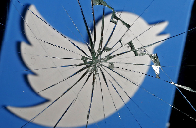 A 3D-printed Twitter logo is seen through broken glass (photo credit: DADO RUVIC/REUTERS)