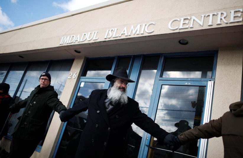 Members of a local church and synagogue form a 'ring of peace' around an Islamic Cultural Center in Toronto after a shooting there, February 2017 (photo credit: MARK BLINCH/ REUTERS)