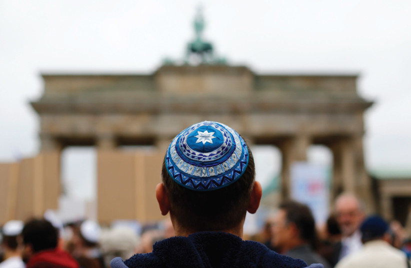 A man wearing a yarmulke looks at the Brandenburg Gate in Berlin. (photo credit: REUTERS)