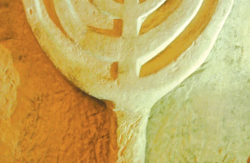 Detail from a catacomb wall and a menorah, at Beit She’arim. (photo credit: SETH J. FRANTZMAN)
