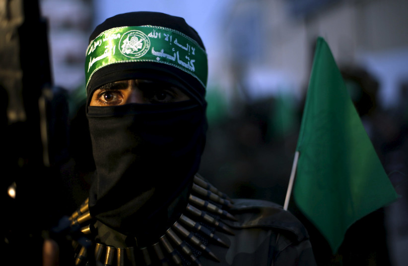 A Palestinian Hamas militant takes part in a Gaza rally marking the twelfth anniversary of the death of late Hamas leader Sheikh Ahmed Yassin. (photo credit: SUHAIB SALEM / REUTERS)