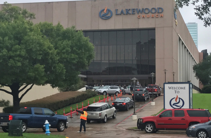 Vehicles queue to deliver supplies for Hurricane Harvey evacuees at the nondenominational Lakewood Church, founded by pastor Joel Osteen, in Houston, Texas, U.S. August 29, 2017 (photo credit: REUTERS/ERNEST SCHEYDER)