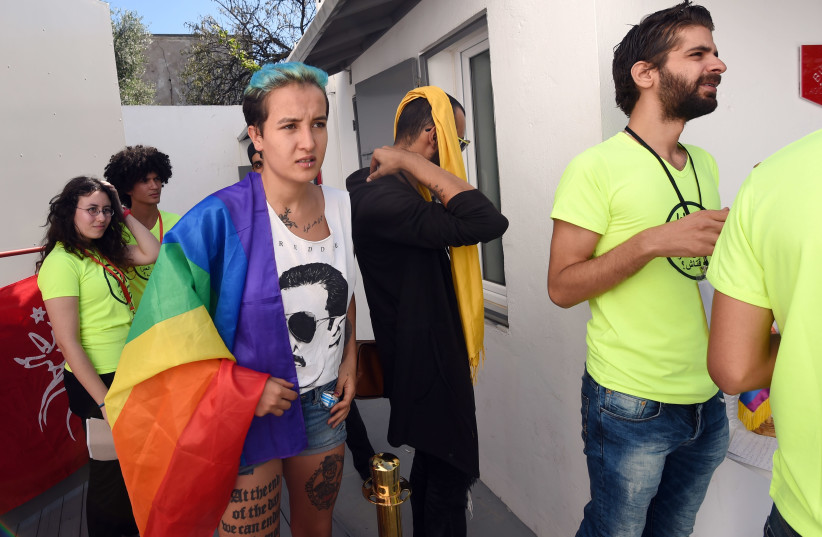Former Tunisian Femen activist Amina Sboui (C) and members of Tunisian "Shams" association for the decriminalisation of homosexuality, wait before a press conference to support a 22-year-old man accused of engaging in homosexual acts and sentenced to a year in prison following an anal examination on (photo credit: FETHI BELAID/AFP)