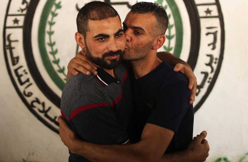 Shadi Abu Obeid (L), a member of the Palestinian Fatah movement, is greeted by a relative in Gaza City after his release from a Hamas prison on October 1, 2017. (photo credit: MAHMUD HAMS / AFP)