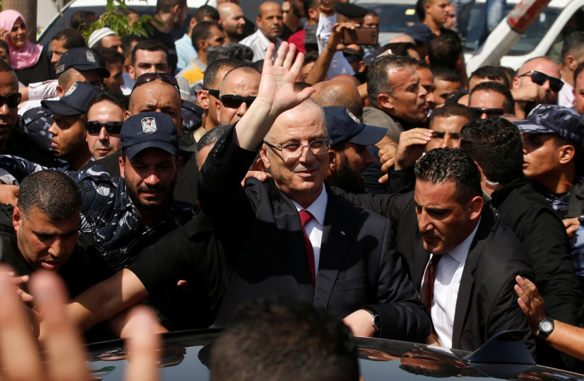 Palestinian Prime Minister Rami Hamdallah waves upon his arrival with his government ministers to take control of Gaza from the Islamist Hamas group (photo credit: MOHAMMED SALEM/ REUTERS)