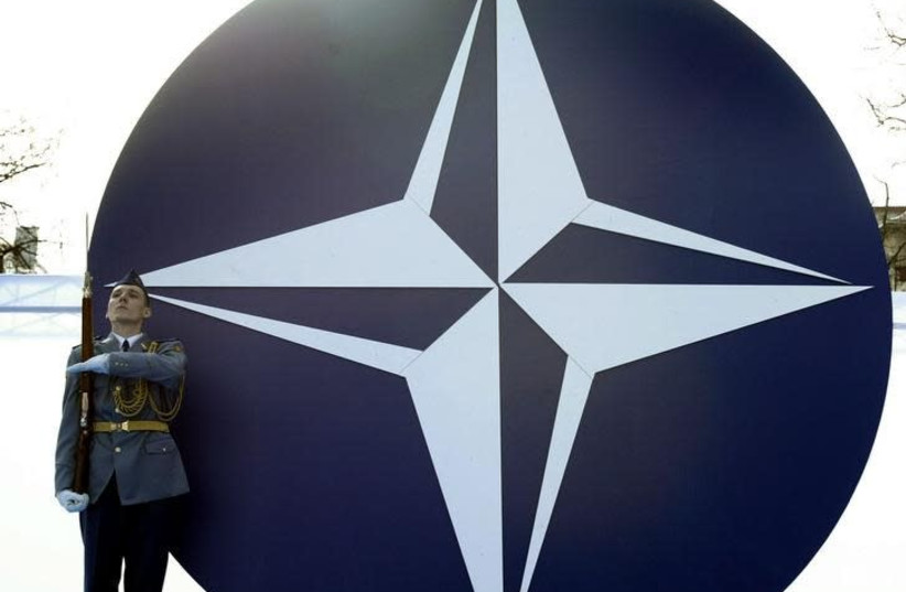 Slovak Army soldier stands guard near a NATO's symbol during a ceremony in Slovakia's capital Bratislava to mark the country's entrance to NATO, April 2, 2004. (credit: REUTERS/PETR JOSEK)