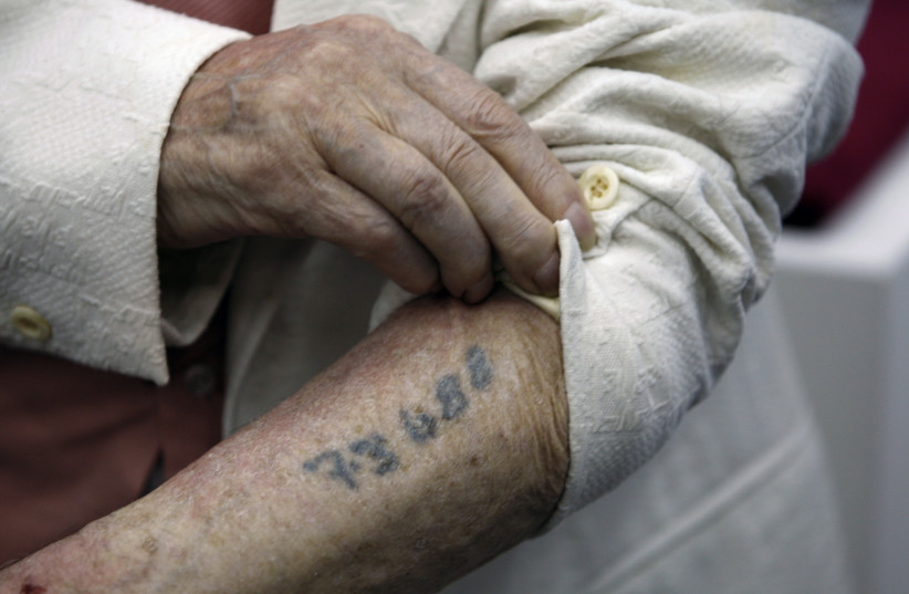 Polish-born Holocaust survivor Meyer Hack shows his prisoner number tattooed on his arm during a news conference at the Yad Vashem Holocaust Museum in Jerusalem June 15, 2009. (credit: REUTERS)