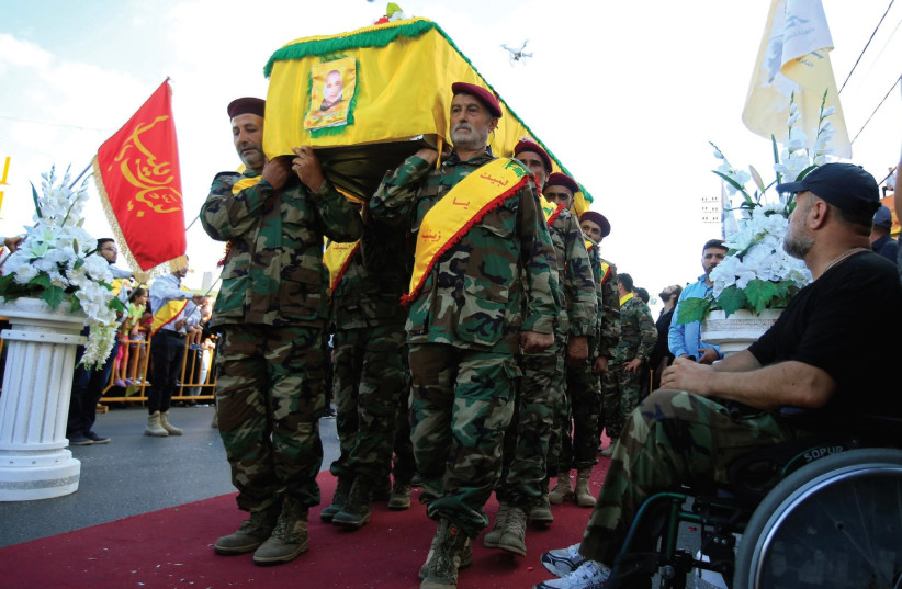  Hezbollah members carry the coffin recently of a senior commander near Nabatieh in southern Lebanon. (photo credit: REUTERS)