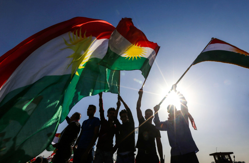 Iraqi Kurds wave flags of Iraqi Kurdistan during a demonstration (photo credit: SAFIN HAMED / AFP)