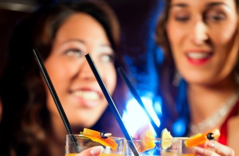 Women drink cocktails at a bar (photo credit: ING IMAGE/ASAP)