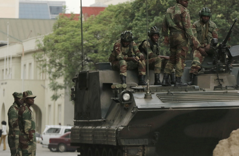 Soldiers are seen next to and on the armoured vehicle on the street in central Harare, Zimbabwe, November 16, 2017. (photo credit: REUTERS)