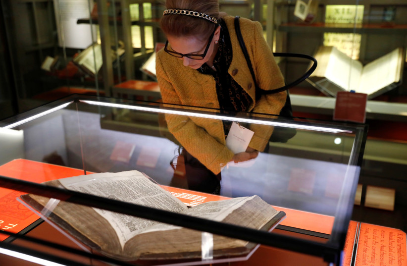 A woman looks at a Bible during a preview of the Museum of the Bible in Washington, U.S., November 14, 2017 (photo credit: KEVIN LAMARQUE/REUTERS)