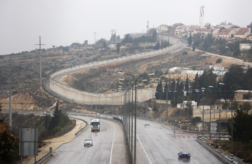 Vehicles drive on Highway 443 past the West Bank Jewish settlement of Beit Horon (credit: AMMAR AWAD / REUTERS)