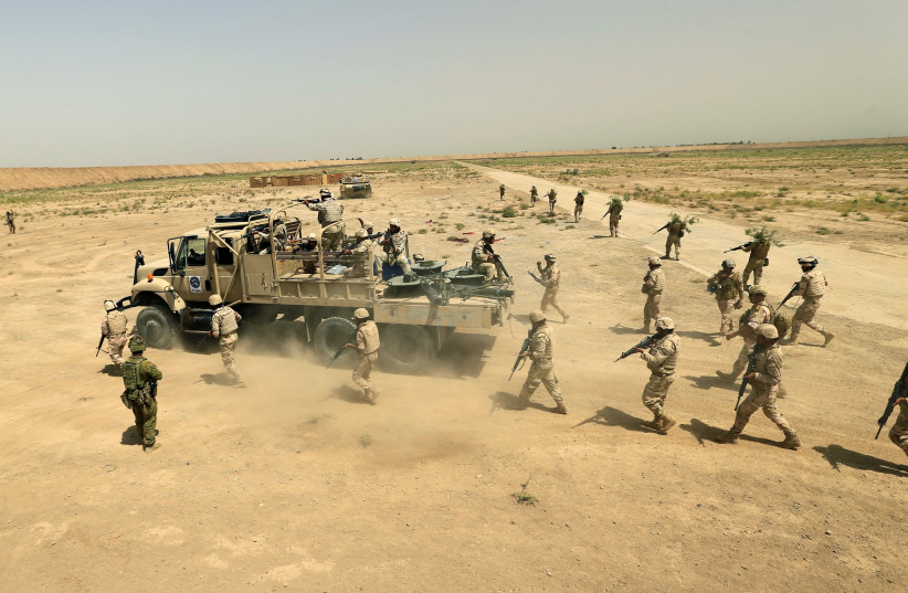 Iraqi army members participate in a live ammunition training exercise with coalition forces trainers at Taji base in August 2017 (photo credit: REUTERS)