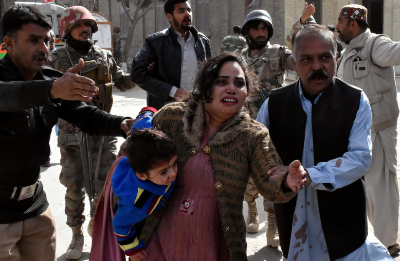 A policeman guides a family after after gunmen attacked the Bethel Memorial Methodist Church in Quetta, Pakistan (photo credit: REUTERS)