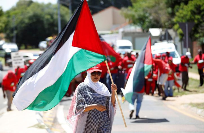 A protester and member of South Africa's ultra-left Economic Freedom Fighters party (EFF), holds a flag outside the Israeli embassy in Pretoria, South Africa, November 2, 2017 (photo credit: REUTERS/SIPHIWE SIBEKO)