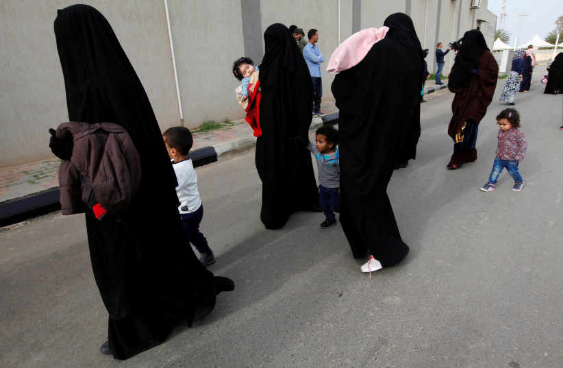 Female jihadists walk with their children at Reform and Rehabilitation foundation in Mitiga in Tripoli, Libya. (photo credit: REUTERS)
