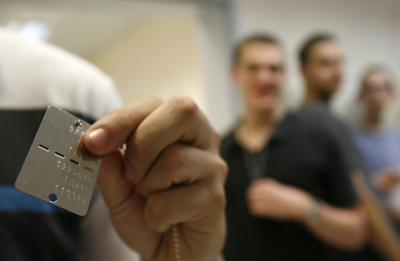 A conscript displays his identifying dog tag at the Tel Hashomer Israel Defence Forces (IDF) Recruitment Center near Tel Aviv March 14, 2010. (credit: REUTERS)