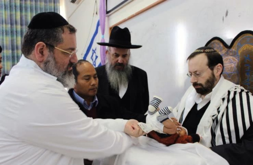 MICHAEL FREUND serves as the ‘sandak’ or godfather at the circumcision ceremony for Ovadiah Daniel Lunghel. (photo credit: Courtesy)