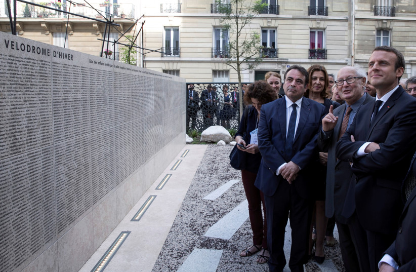 French President Emmanuel Macron (R) listens to Serge Klarsfeld, a French historian, lawyer and Holocaust survivor, as he presents him the "Jardin du souvenir", Garden of Memory, during a ceremony commemorating the 75th anniversary of the Vel d'Hiv roundup in Paris, France, July 16, 2017.  (photo credit: REUTERS)
