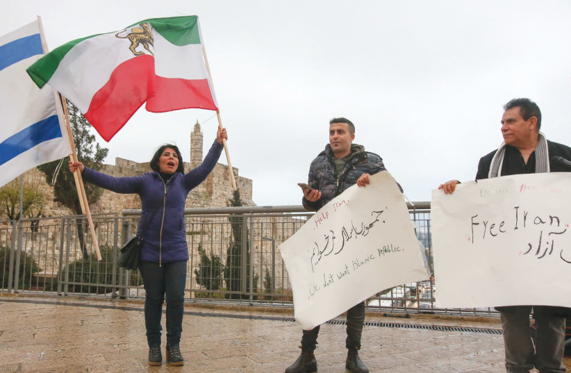 IRANIAN BLOGGER and human rights activist Neda Amin, waving the former Iranian flag and the Israeli flag, leads a small rally in Jerusalem on Tuesday in solidarity with protesters in Iran. (photo credit: MARC ISRAEL SELLEM/THE JERUSALEM POST)