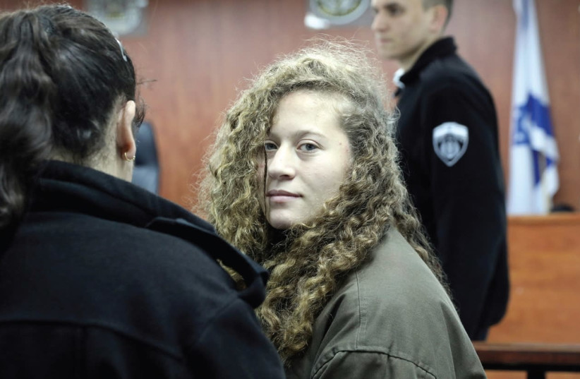 Ahed Tamimi (center) enters a military courtroom at Ofer Prison near Ramallah on New Year’s Day. (photo credit: AMMAR AWAD/REUTERS)
