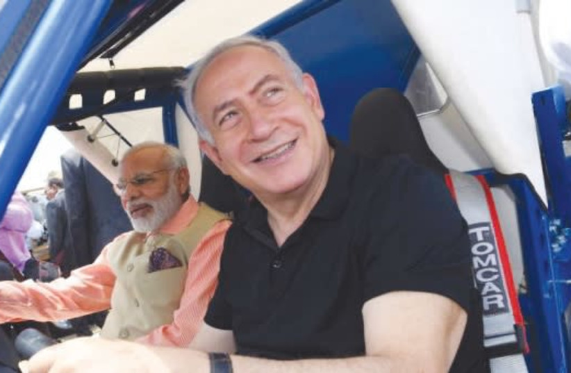 Prime Minister Benjamin Netanyahu and Indian Prime Minister Narendra Modi ride in a GalMobile water desalination and purification jeep at Olga Beach last July (photo credit: KOBI GIDEON/GPO)