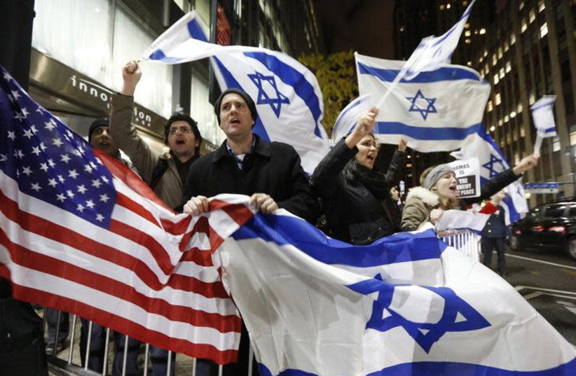 People hold U.S. and Israel flags as they chant during a Pro-Israel rally outside the Israeli consulate in New York November 19, 2012. (photo credit: BRENDAN MCDERMID/REUTERS)