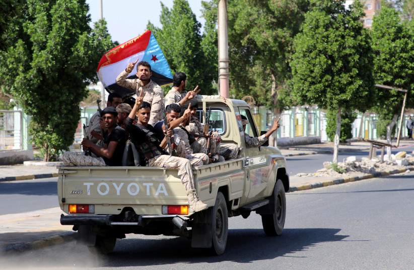 Southern Yemeni separatist fighters flash the V sign as they ride on the back of a truck in Aden, Yemen (photo credit: FAWAZ SALMAN/REUTERS)