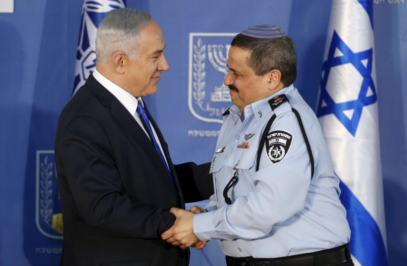 Israeli Prime Minister Benjamin Netanyahu (L) congratulates new police commissioner Roni Alsheich after he received his ranks during a ceremony in Jerusalem December 3, 2015. (photo credit: REUTERS)
