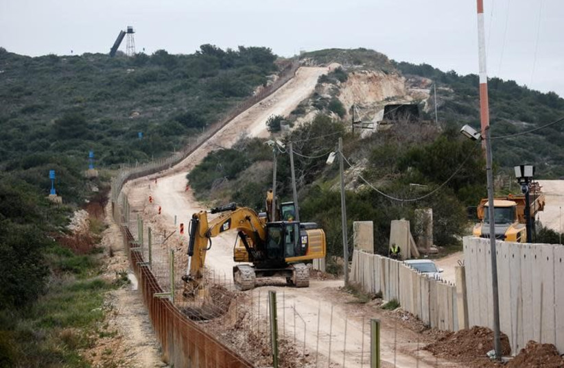 Israeli workers are seen building a wall near the border with Israel near the village of Naqoura, Lebanon February 8, 2018 (photo credit: REUTERS/ALI HASHISHO)