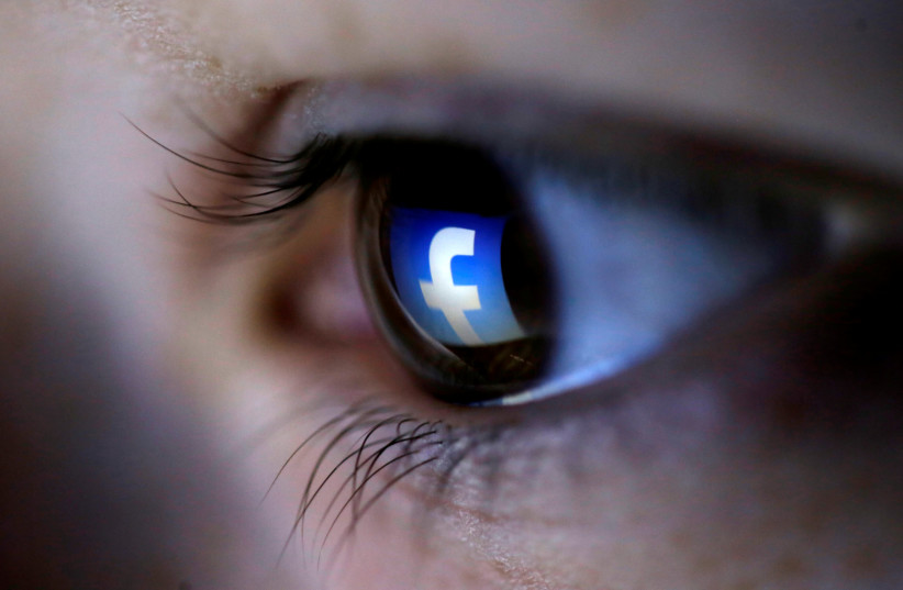 A picture illustration shows a Facebook logo reflected in a person's eye (photo credit: REUTERS/DADO RUVIC/ILLUSTRATION/FILE PHOTO)