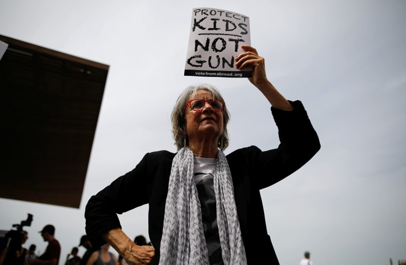 A woman takes part in a protest in front of the US Embassy, calling for enhanced gun control in the US, in Tel Aviv, Israel, March 23, 2018. (credit: REUTERS/CORINNA KERN)