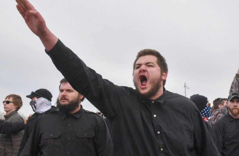 A MEMBER of a neo-Nazi party gives a salute outside a speech by Richard Spencer on the campus of Michigan State University on March 5 (photo credit: REUTERS/STEPHANIE KEITH)