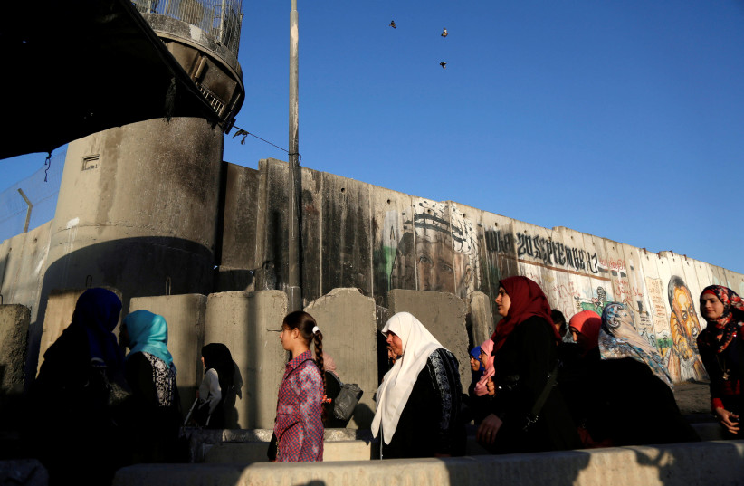 Palestinians wait to cross through Israeli Kalandiya checkpoint (photo credit: MOHAMAD TOROKMAN/REUTERS)