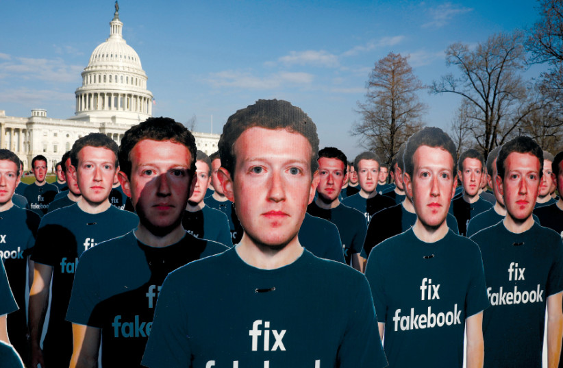 DOZENS OF cardboard cutouts of Facebook CEO Mark Zuckerberg are seen during a protest outside the US Capitol in Washington, April 2018 (photo credit: AARON P. BERNSTEIN/ REUTERS)