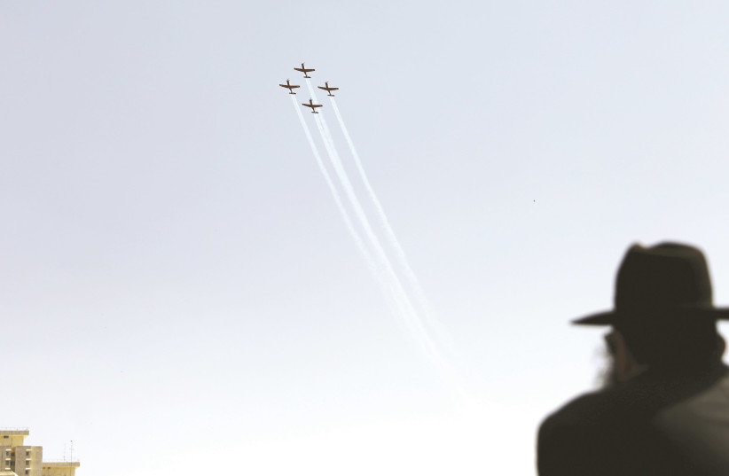 An ultra-Orthodox man watches planes fly overhead. (photo credit: REUTERS)