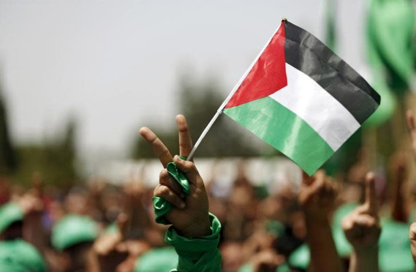 A student supporting Hamas holds a Palestinian flag in a rally during an election campaign for the student council at the Birzeit University in the West Bank city of Ramallah April 26, 2016 (credit: MOHAMAD TOROKMAN/REUTERS)