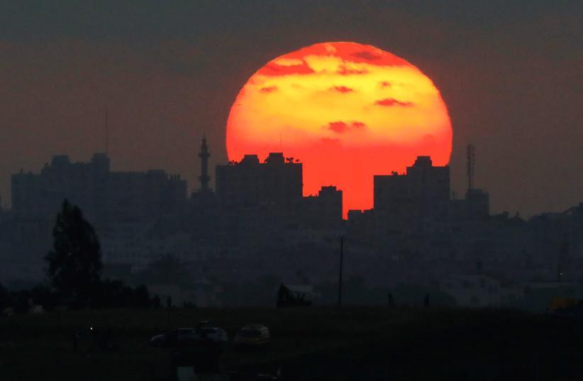 The sun sets over the Gaza Strip, as seen from the Israeli side of the border May 15, 2018 (photo credit: AMIR COHEN/REUTERS)