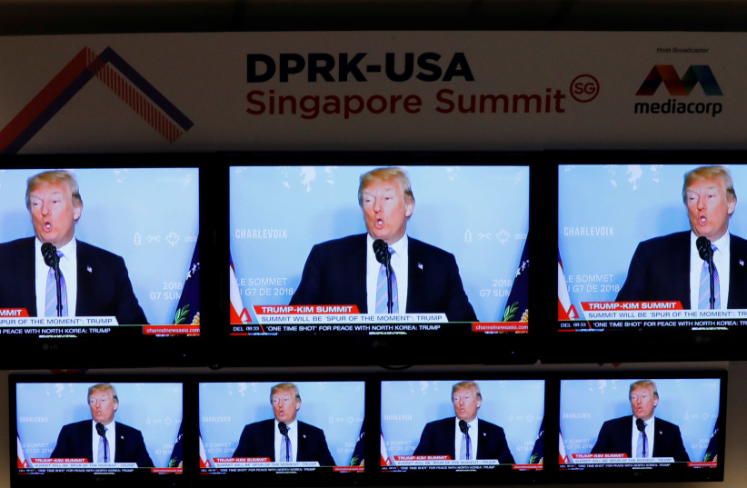 A TV news reports about U.S. President Donald Trump is projected on TV sets at a media center for the summit between the U.S and North Korea in Singapore (photo credit: REUTERS/KIM KYUNG-HOON)