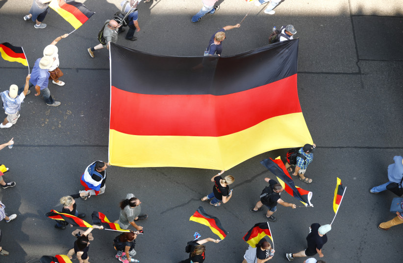 Supporters of the Anti-immigration party Alternative for Germany (AfD) hold German flags during a protest in Berlin, Germany May 27, 2018 (credit: REUTERS/HANNIBAL HANSCHKE)