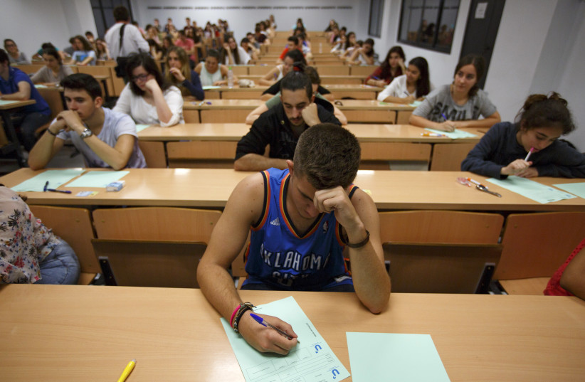 Students take a university entrance examination at a lecture hall in the Andalusian capital of Seville, southern Spain, June 16, 2015. Students in Spain must pass the exam after completing secondary school in order to gain access to university. REUTERS/Marcelo del Pozo (photo credit: MARCELO DEL POZO/REUTERS)