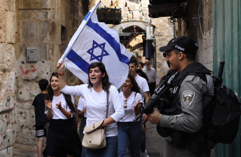 Jewish women march while police patrol in the Old City during Jerusalem Day, 2019 (photo credit: MARC ISRAEL SELLEM/THE JERUSALEM POST)
