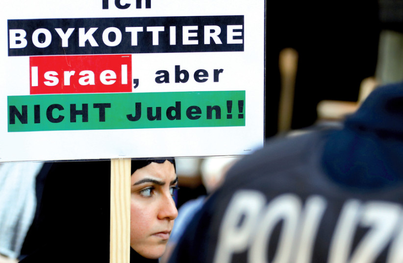 A protester holds a placard reading ‘I boycott Israel, but not the Jews,’ during a demonstration marking al-Quds Day (Jerusalem Day), in Berlin on June 1 (photo credit: FABRIZIO BENSCH / REUTERS)